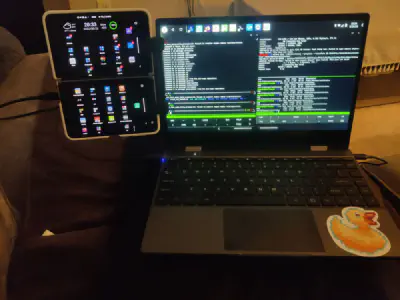 The NexDock with the Surface Duo attached via a clip to the left side of the screen. It looks like someone attached a folded phone to the side of a laptop.