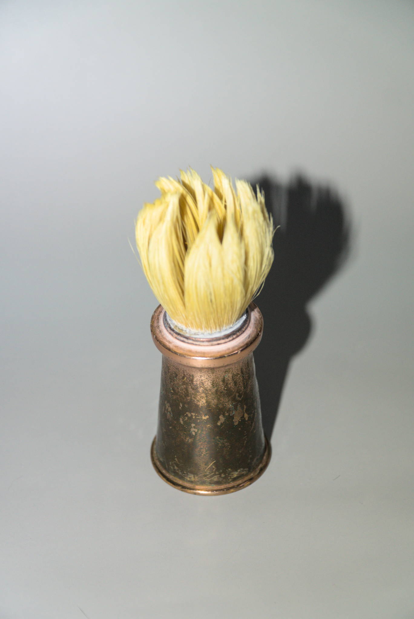 A copper shave brush with boar hair knot