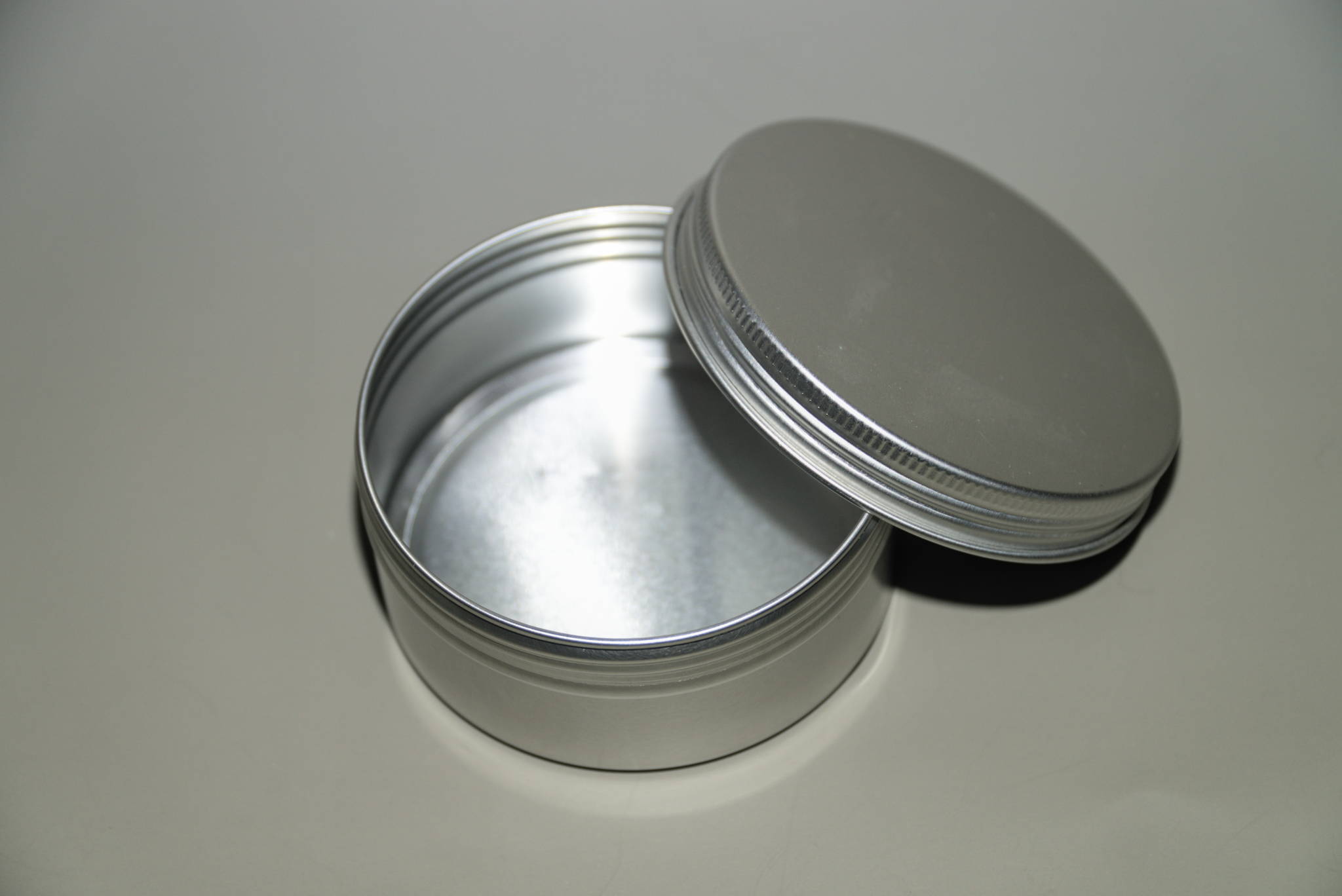 A screw top, aluminum travel tin for bar soap