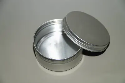 A screw top, aluminum travel tin for bar soap