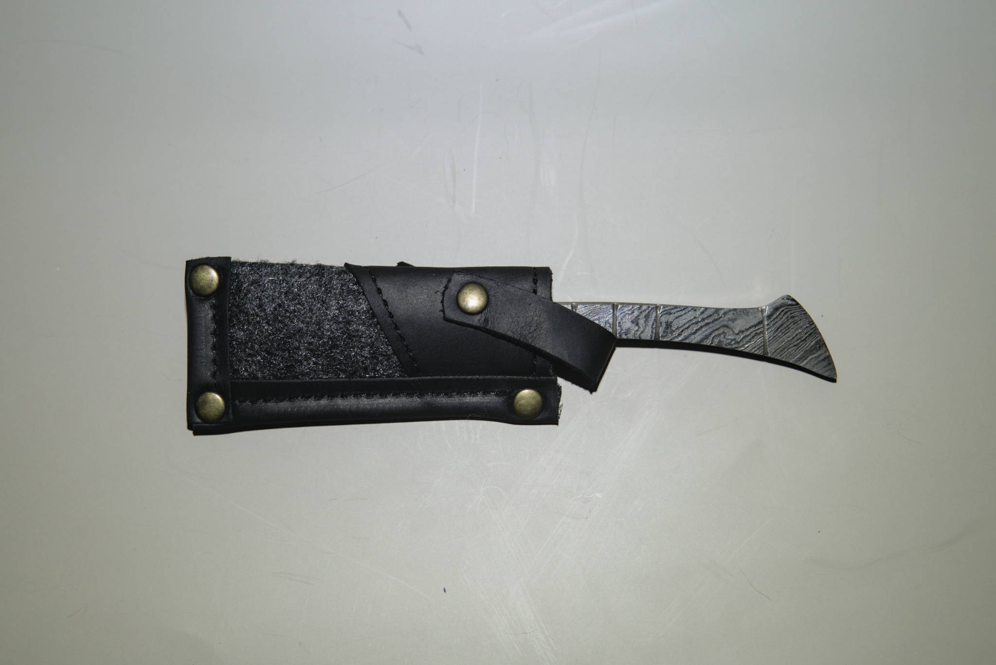 A straight handle damascus straight razor in a case