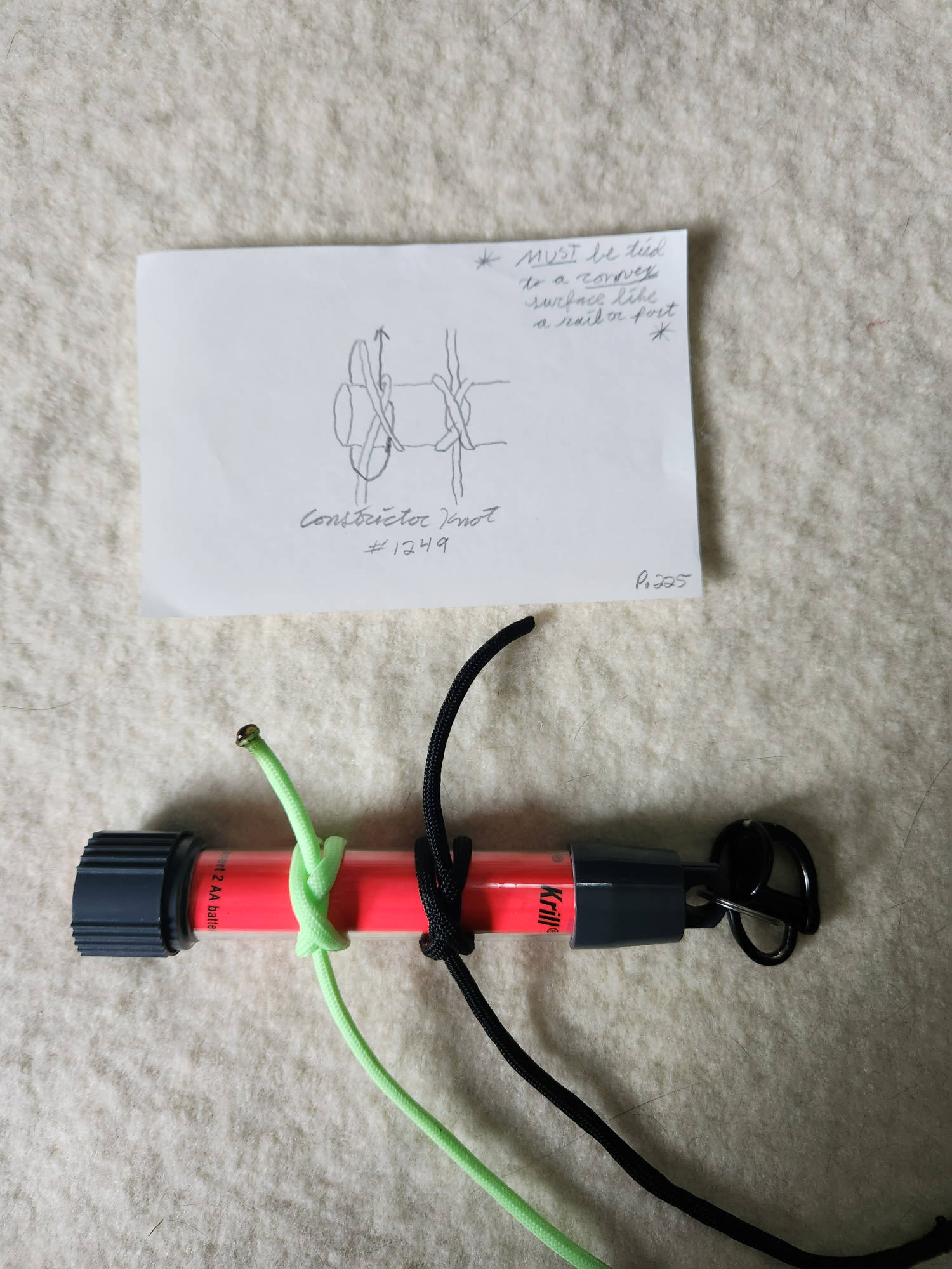 An example image showing the Constrictor Knot (#1249) tied around a Krill AA glow stick light