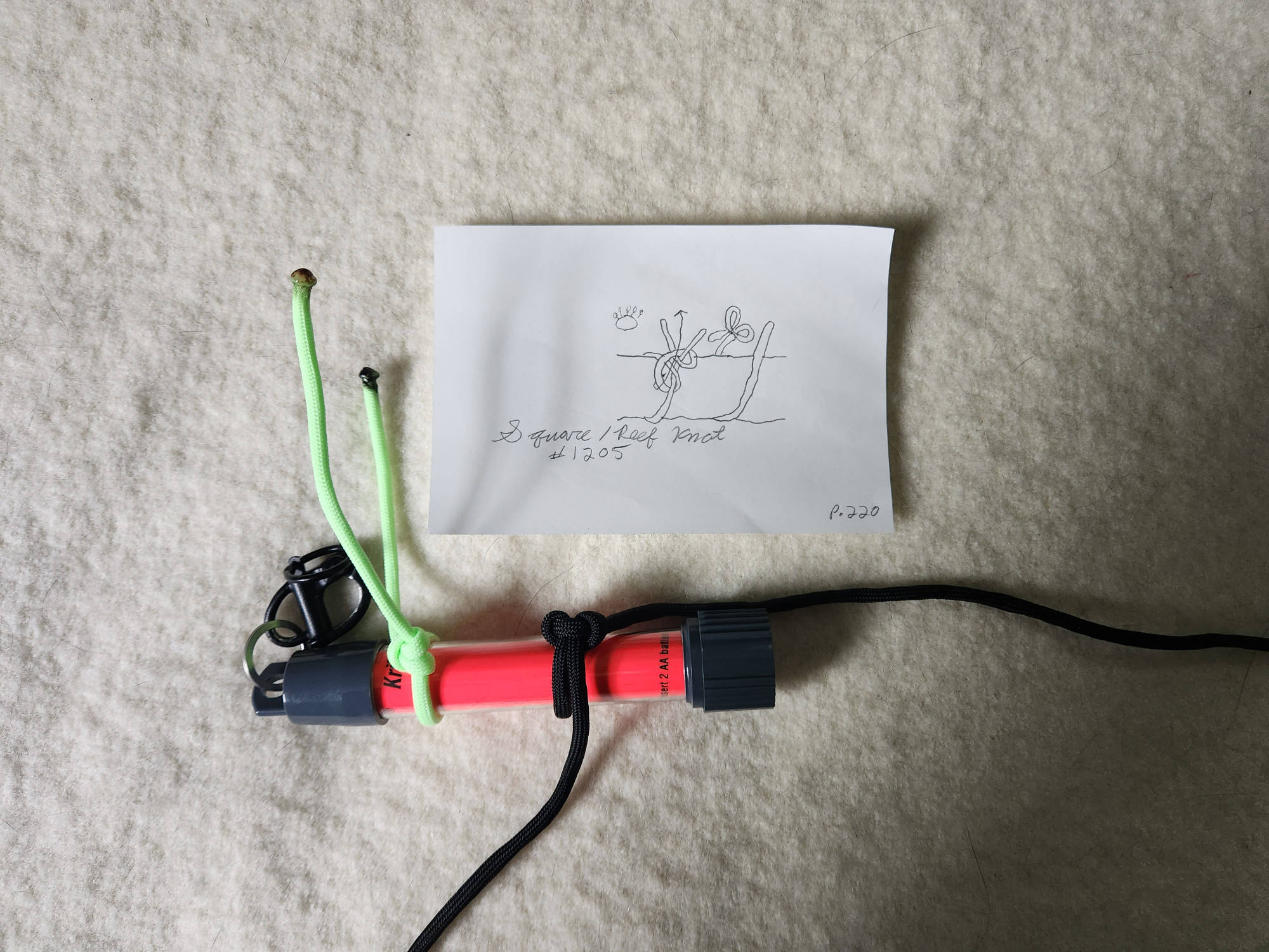 An example image showing the Square / Reef Knot (#1205) tied around a Krill AA glow stick light