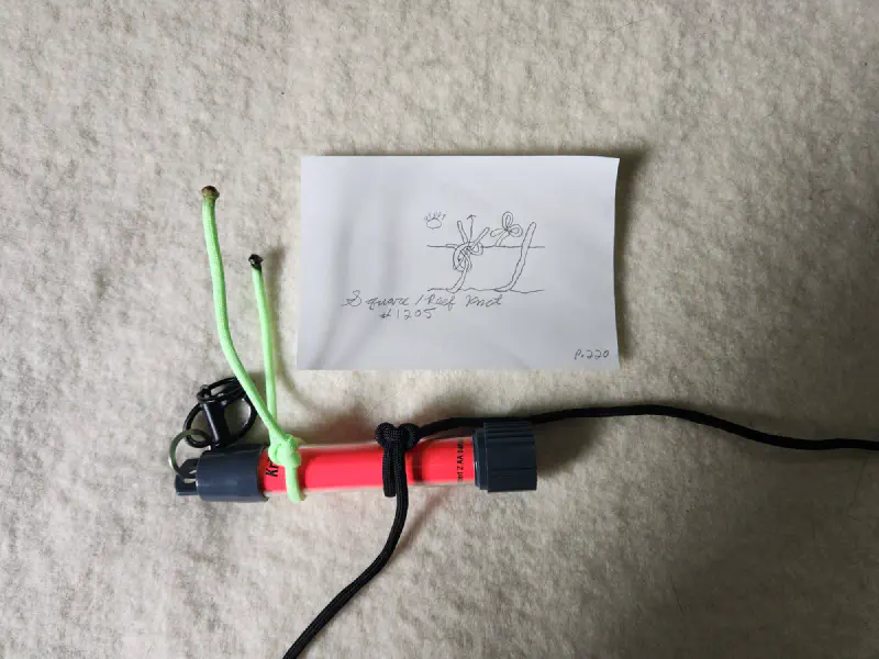 An example image showing the Square / Reef Knot (#1205) tied around a Krill AA glow stick light