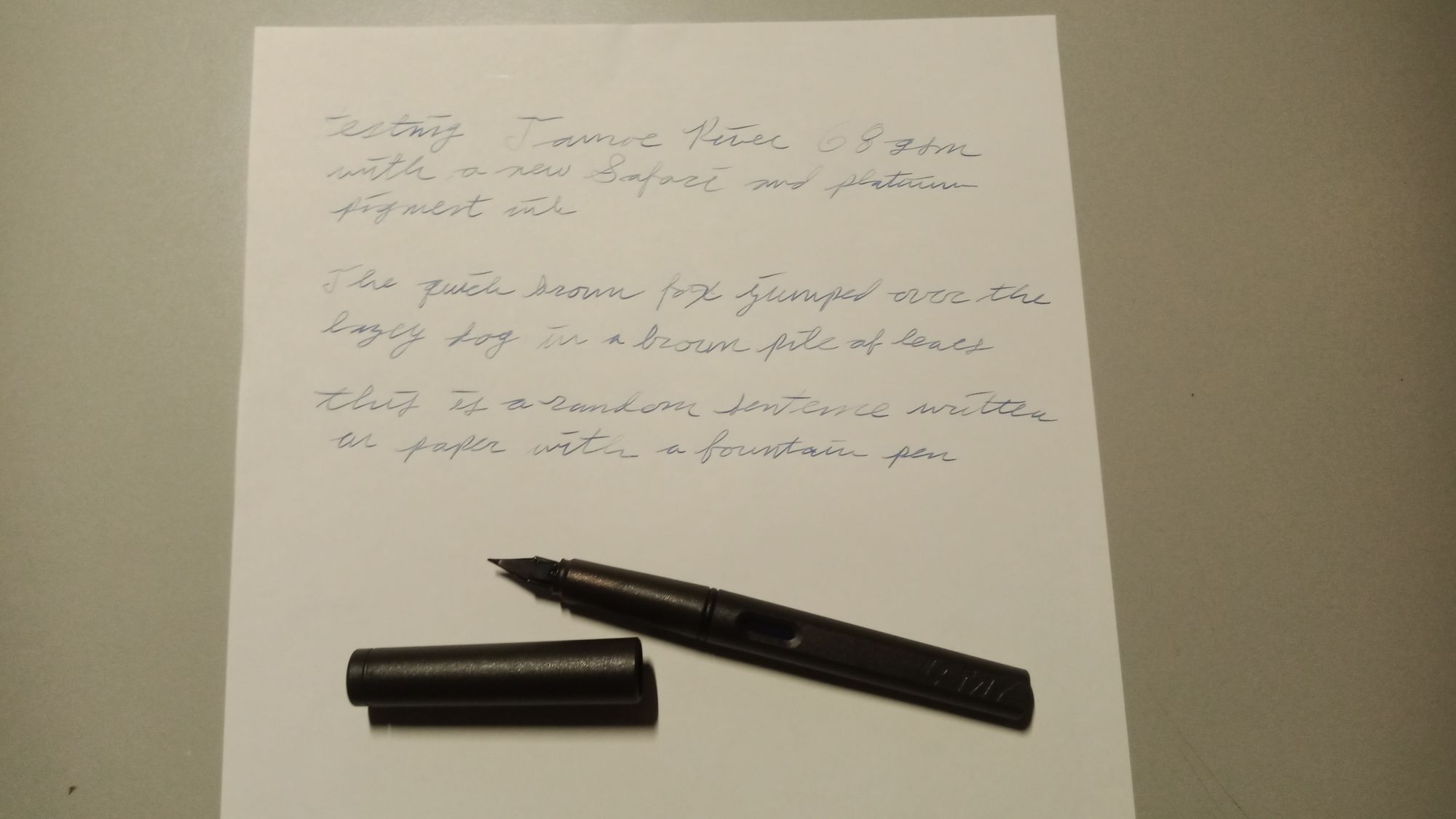 A sheet of Tamoe River paper with test writing on it and an uncapped fountain pen resting just below the writing