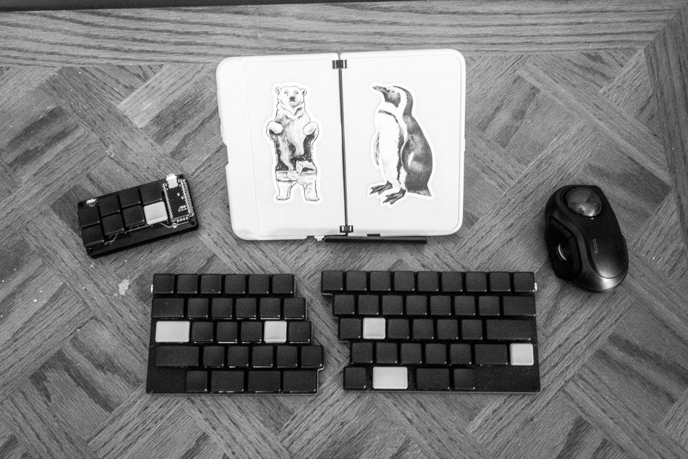 A Surface Duo folding phone, Elecom Bitra trackball, 7skb keyboard, The Paintbrush keyboard shown setup how I might use them day to day