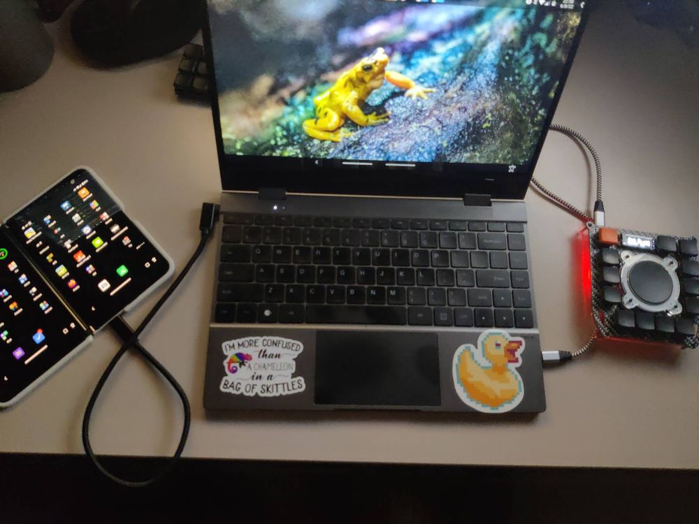 A Surface Duo foldable phone connected to the NexDock and a PuckBuddy ready for use as a laptop