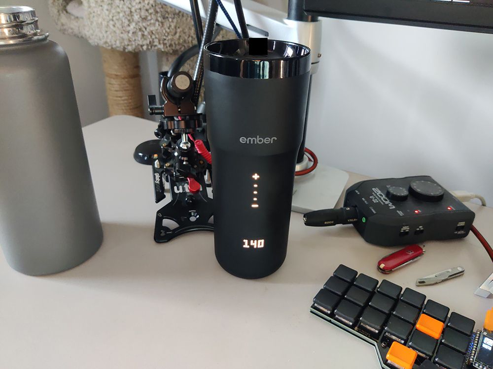 The Ember mug on my desk next to my water bottle, microphone and keyboard. It's on the left hand side of the desk.